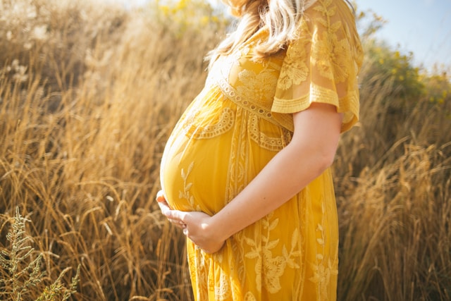 妊婦がお腹を押さえている画像