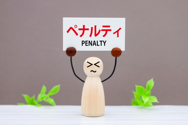 木の人形がペナルティと書かれた紙を持ち上げている画像