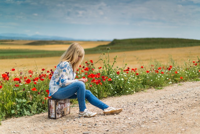 道端にいる少女がトランクに座っている画像
