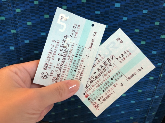 新幹線のチケットを2枚持っている女性の手の画像