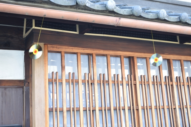 軒下に吊るされた鳥よけCDの画像