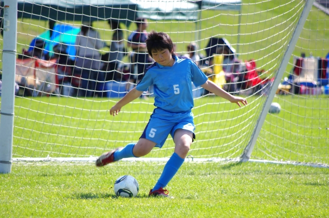 サッカーボールを蹴る少年