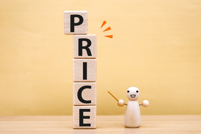 「price」と書かれたウッドブロックを指している木彫りの人形の画像