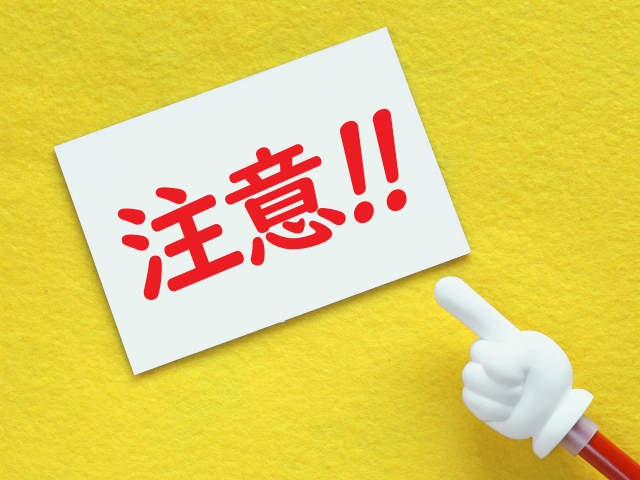 画用紙に赤文字で「注意!!」と書かれた紙を指さしている画像