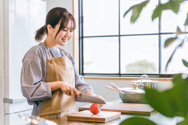 野菜を切っている女性の画像