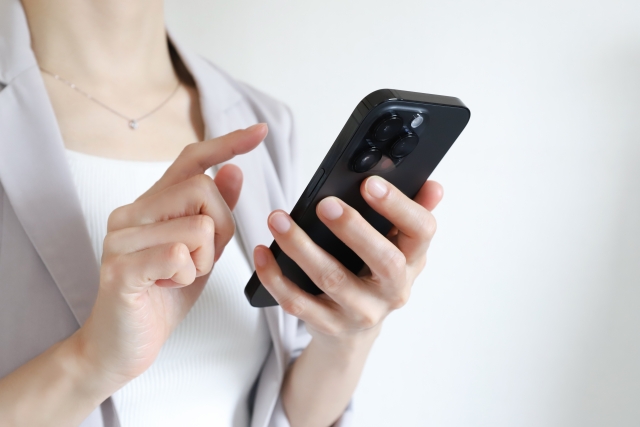 女性がスマホを触っている画像