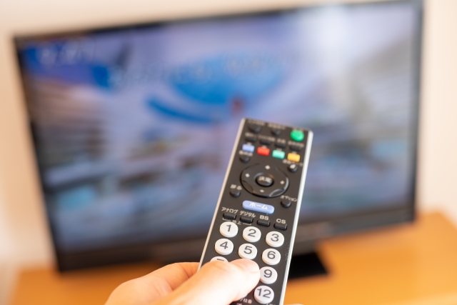 テレビのリモコンでチャンネルを変えている画像