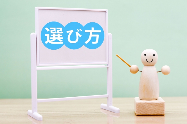 「選び方」と書かれたホワイトボードとそれを指している木彫りの人形の画像