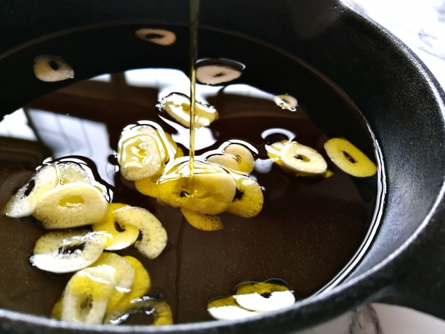 鍋に、にんにくとオイルが入っている画像