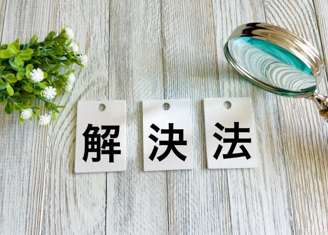 解・決・法と書かれた紙の周りに虫眼鏡と葉がある画像