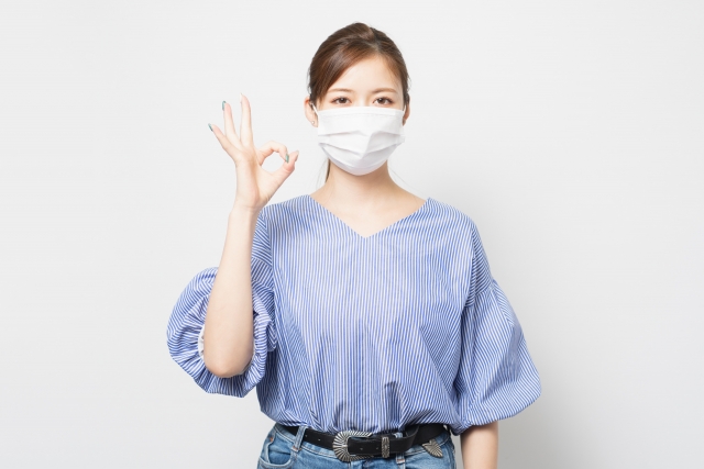 マスクをつけてオッケーサインをしている女性の画像