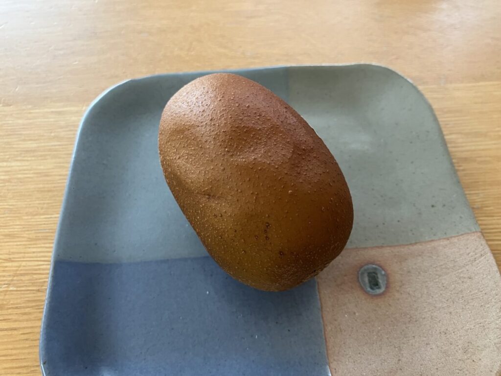 皮がシワシワしている丸のままのゴールドキウイの画像