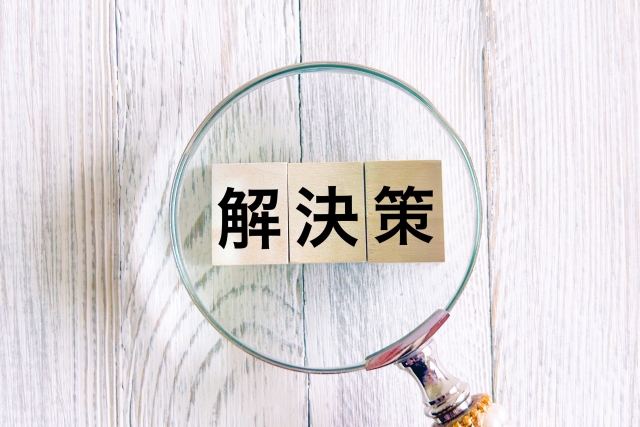 解決策とかかれたブロックを虫眼鏡で覗いている画像